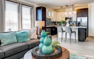 Apartments in Tempe AZ - Vela at Tempe Town Lake - Furnished Living Room With Stylish Furniture, a Coffee Table, and Windows With Blinds and Curtains